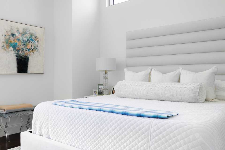 white bedroom of primary suite with abstract flower artwork 